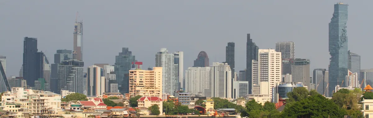 Bangkok's skyline with modern skyscrapers along the Chao Phraya River.