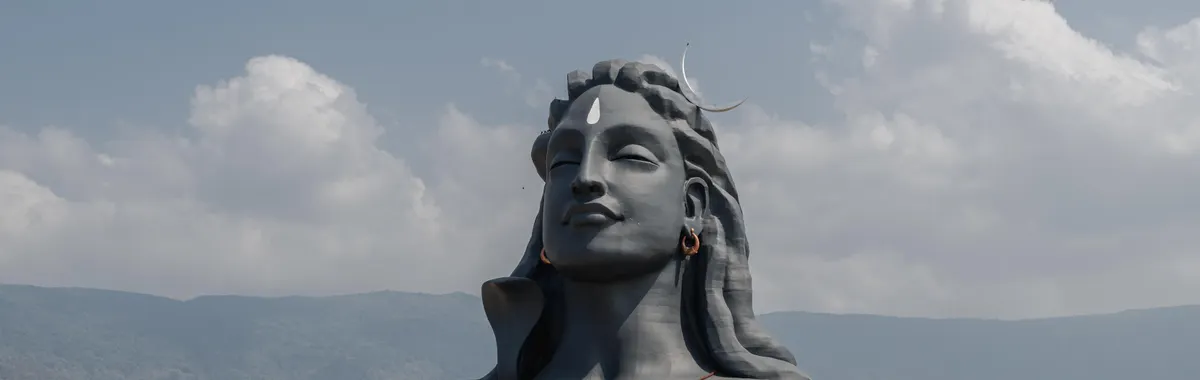 Breathtaking Adiyogi statue in Coimbatore, India, surrounded by mountains and visitors.