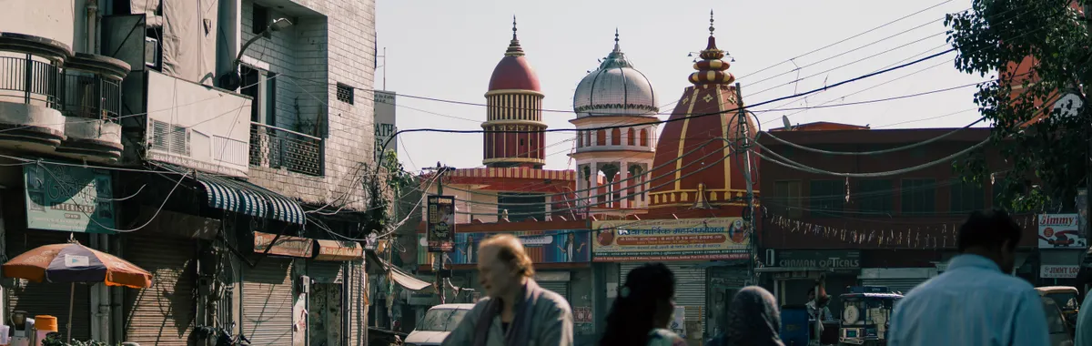 Street view with people and local architecture, highlighting a temple in Ludhiana, Punjab, India.