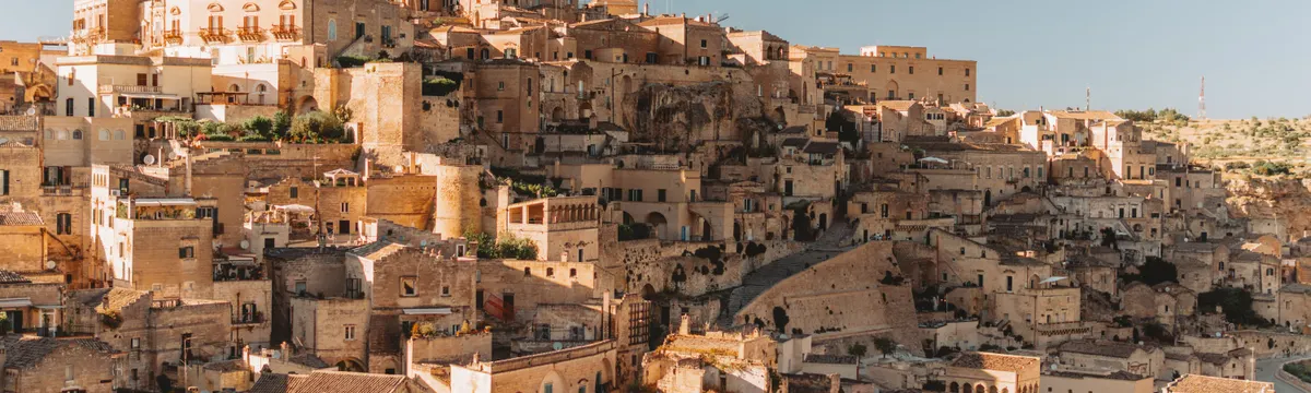 איטליה: Explore the ancient stone dwellings of Matera, Italy, a UNESCO World Heritage site bathed in golden light.