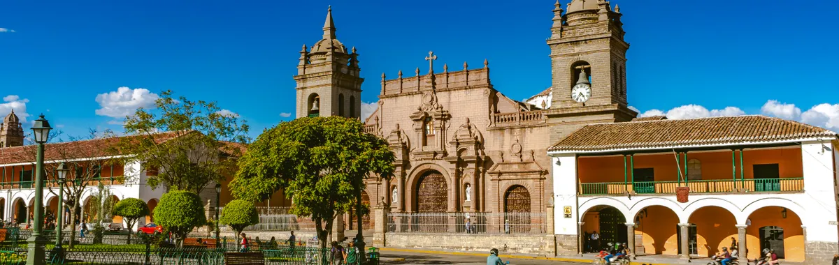 Historic colonial architecture in Sucre's main city square, Bolivia, under a bright blue sky.