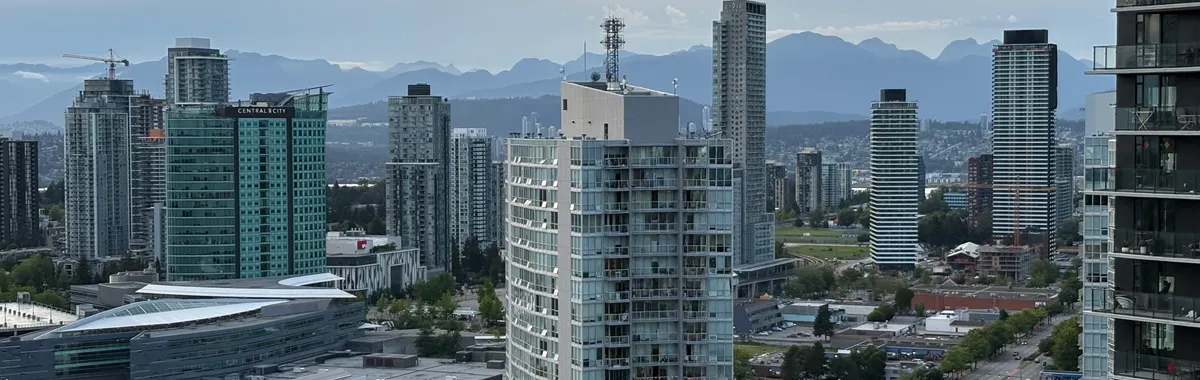 Stunning skyline of Surrey, British Columbia with distant mountains under a twilight sky.