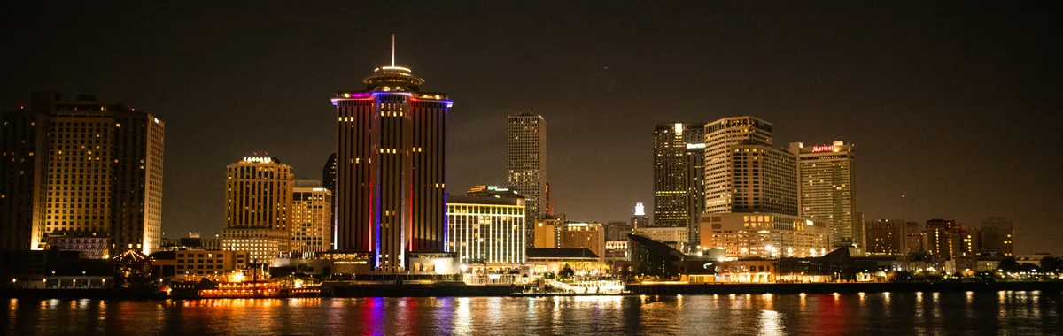 Captivating night shot of New Orleans skyline reflecting on the Mississippi River.