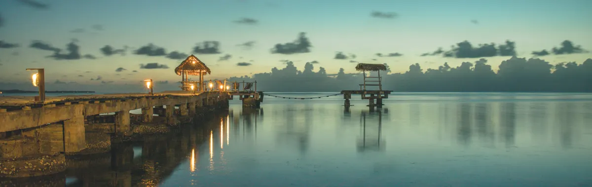 Serene view of a wooden dock at sunrise over calm waters in Toamasina Province, Madagascar.