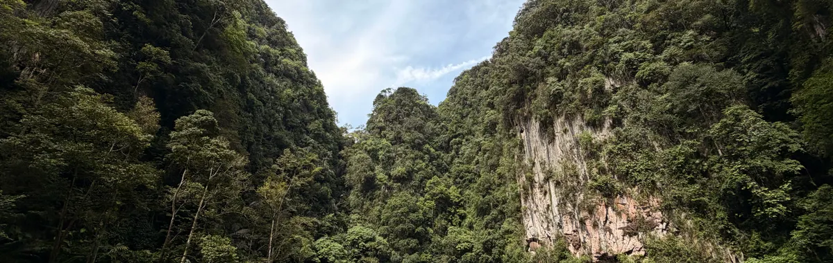 A tranquil view of limestone hills and a serene lake at Gunung Lang, Ipoh, Malaysia.