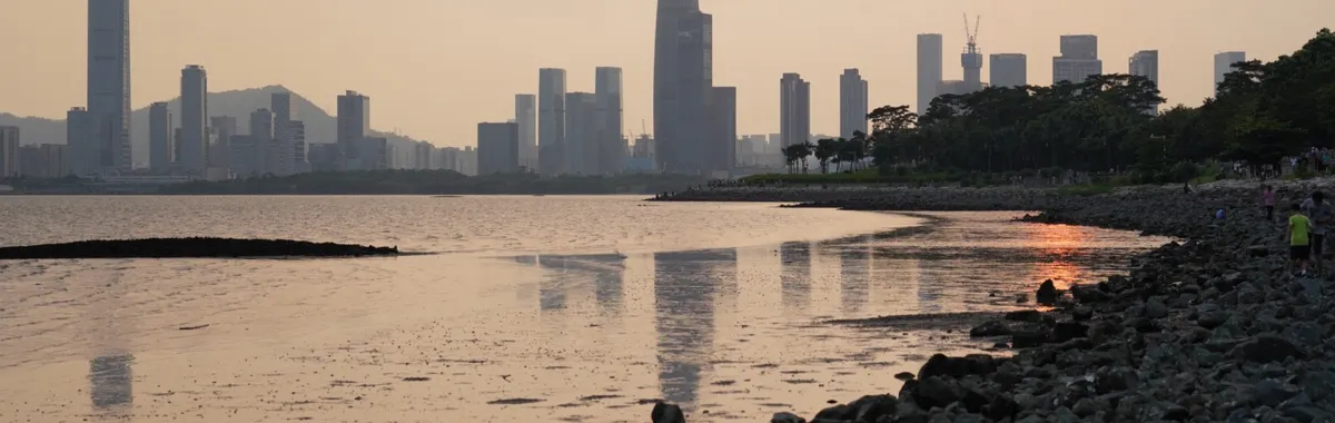 Scenic view of Shenzhen skyline reflecting over the water at sunset.