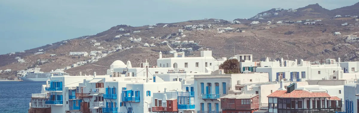 Picturesque waterfront buildings in Mykonos, Greece, showcasing unique Cycladic architecture against the Aegean Sea.
