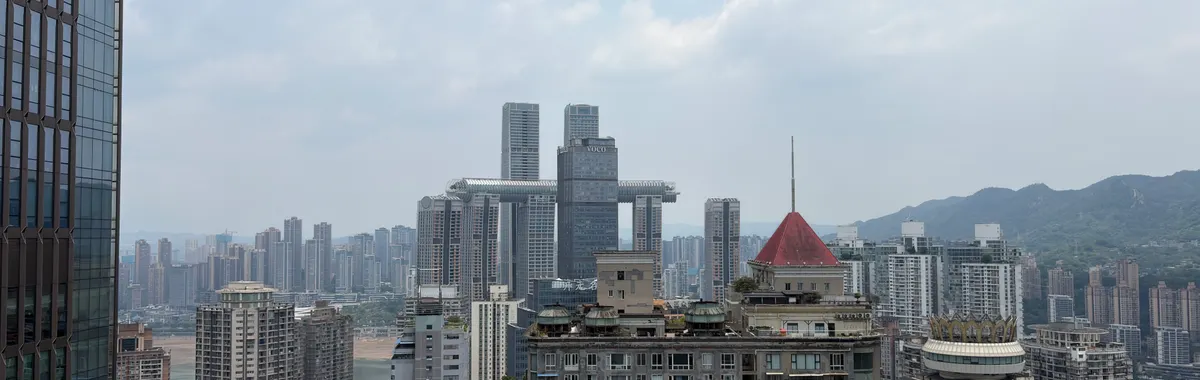 View of Chongqing, China skyline featuring modern architecture under a cloudy sky.