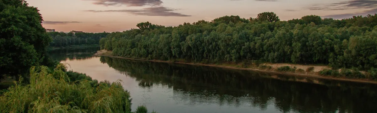 אוקראינה: Captivating summer sunset reflecting on the Desna River near Chernihiv, surrounded by lush greenery.