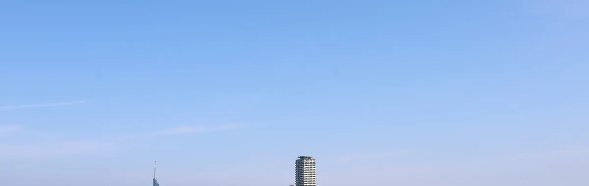 Panoramic skyline of Fukuoka City featuring iconic buildings along the waterfront under a clear blue sky.