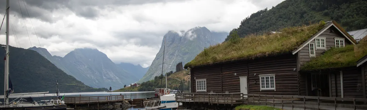 נורווגיה: Tranquil scene of a fjord with boats and traditional cabins in Møre og Romsdal, Norway.