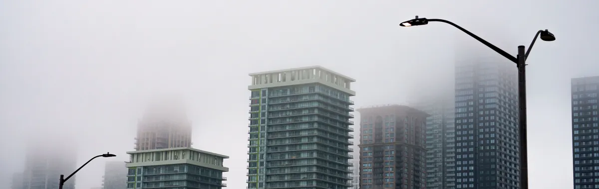 Mist envelops skyscrapers in Mississauga, Ontario, creating a mysterious urban scene.