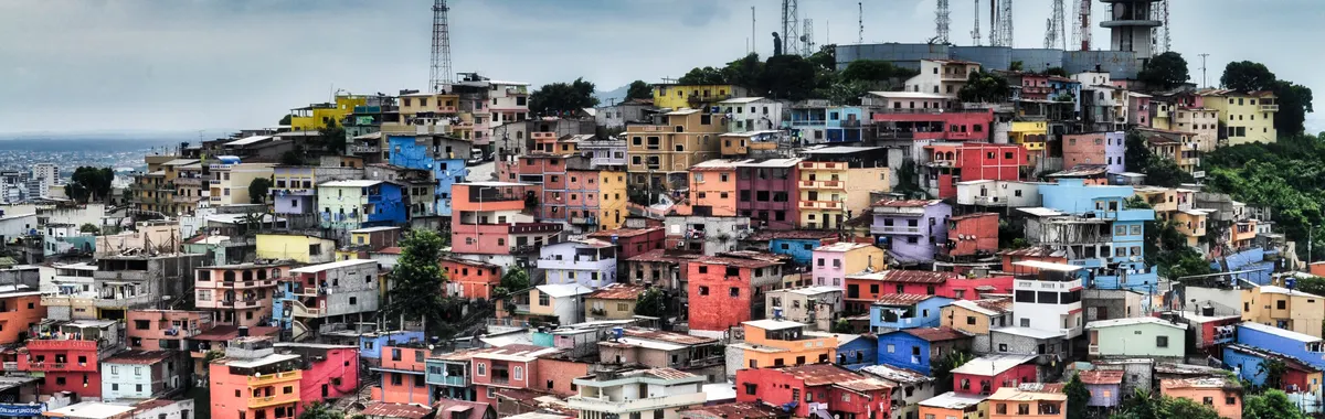 Colorful homes on Santa Ana Hill in Guayaquil, Ecuador under a dramatic sky.