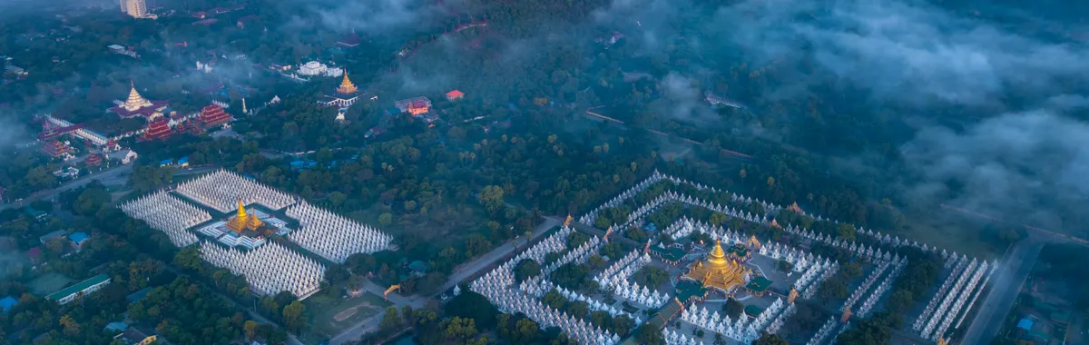 Stunning aerial photo capturing Mandalay's temples amidst clouds and mountains.