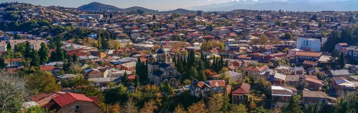 Explore the stunning aerial view of Kutaisi, Georgia, showcasing vibrant architecture and lush greenery.