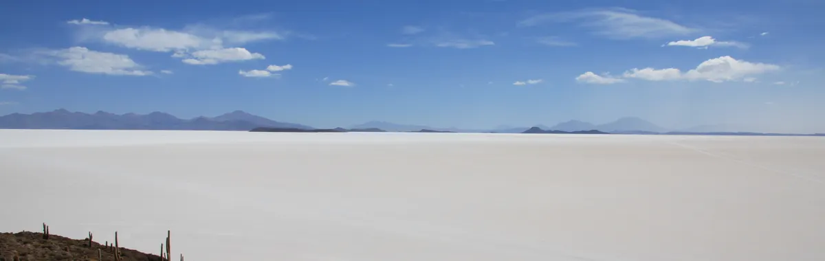 Breathtaking landscape of Salar de Uyuni with clear skies and distant mountains.