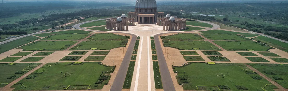 Drone shot of the Basilica of Our Lady of Peace with expansive gardens in Yamoussoukro, Côte d'Ivoire.