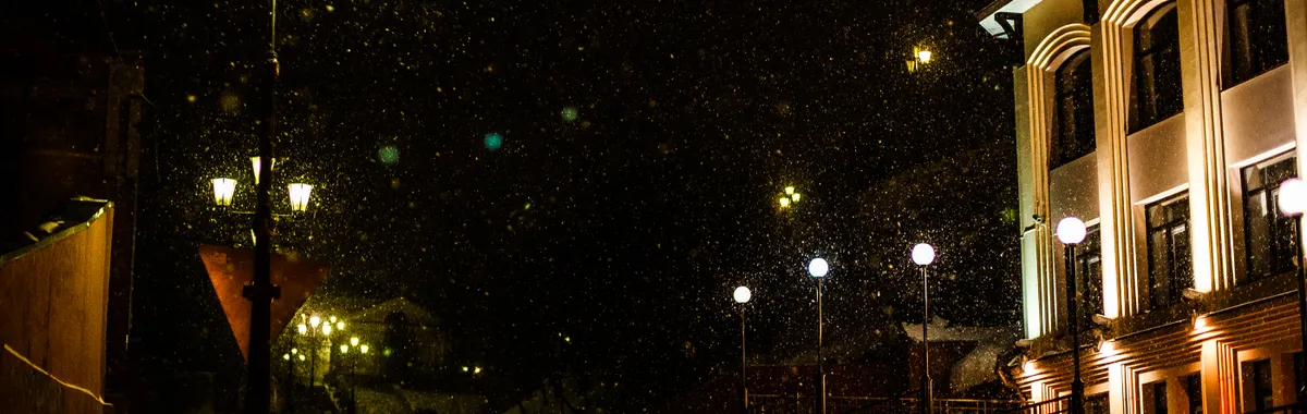 A calming snowy street scene in Tomsk, Russia, illuminated by elegant lanterns on a winter night.