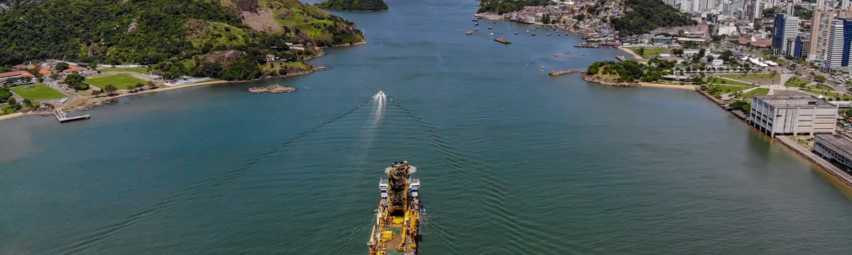 ברזיל: Aerial view of Vitória, Brazil, showcasing the city's waterfront and a large ship navigating the channel.
