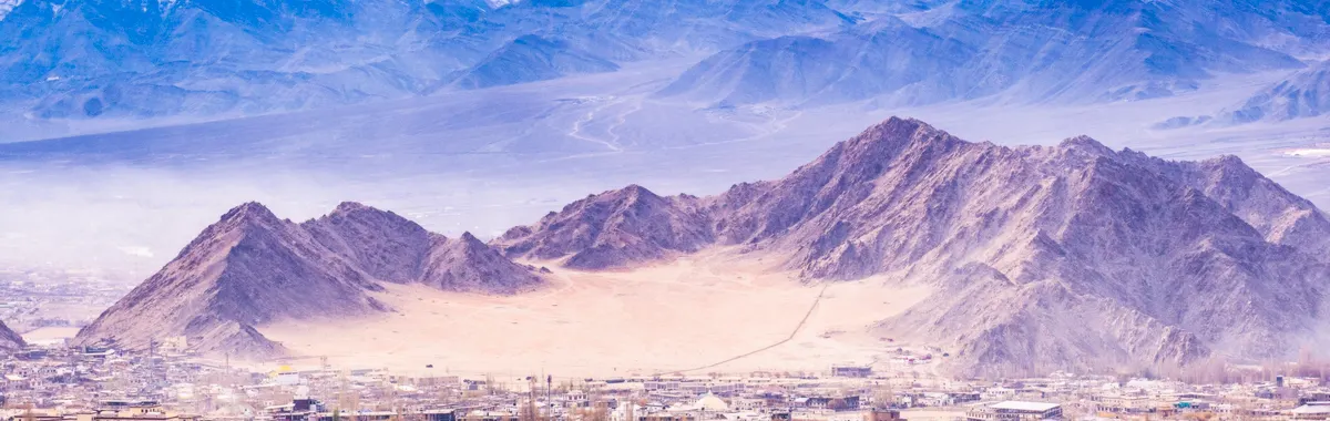 Breathtaking aerial view of Leh in Ladakh, India, surrounded by majestic snow-capped mountains.
