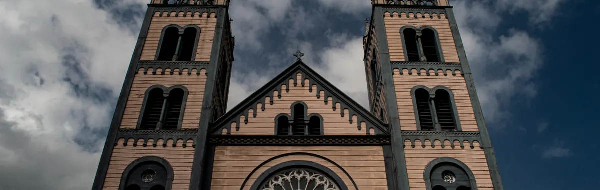 סורינאם: Exterior view of St. Peter and Paul Cathedral showcasing its gothic architecture and twin towers in Suriname.
