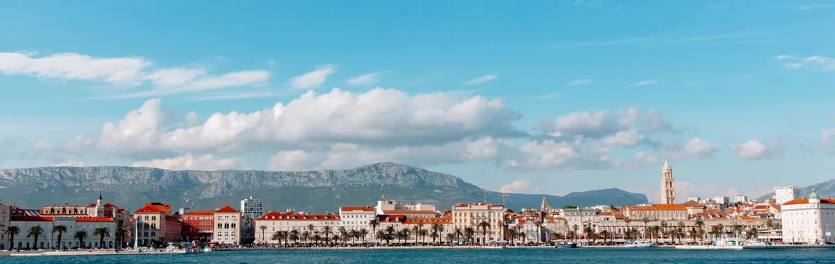 Discover the picturesque coastal cityscape of Split, Croatia, with its charming harbor and mountain backdrop.
