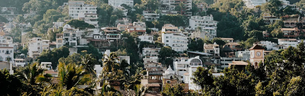 Lush greenery and urban landscape blend in Puerto Vallarta's hillside view.