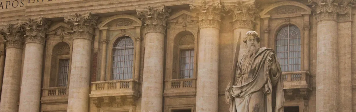 The majestic facade of St. Peter's Basilica in Vatican City featuring a prominent statue.