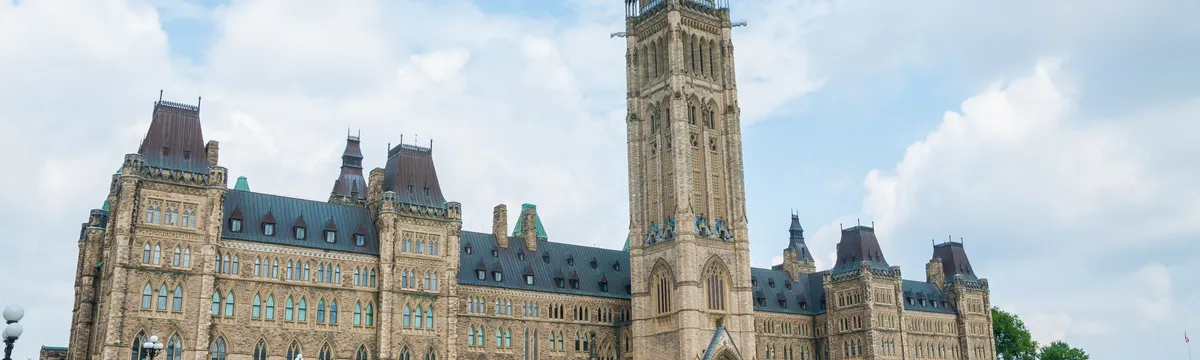 קנדה: Stunning photo of Canada's Parliament Hill in Ottawa under a clear sky, showcasing Gothic Revival architecture.