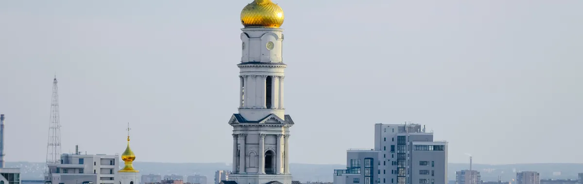 Elegant Baroque architecture of Assumption Cathedral amidst modern Kharkiv cityscape.