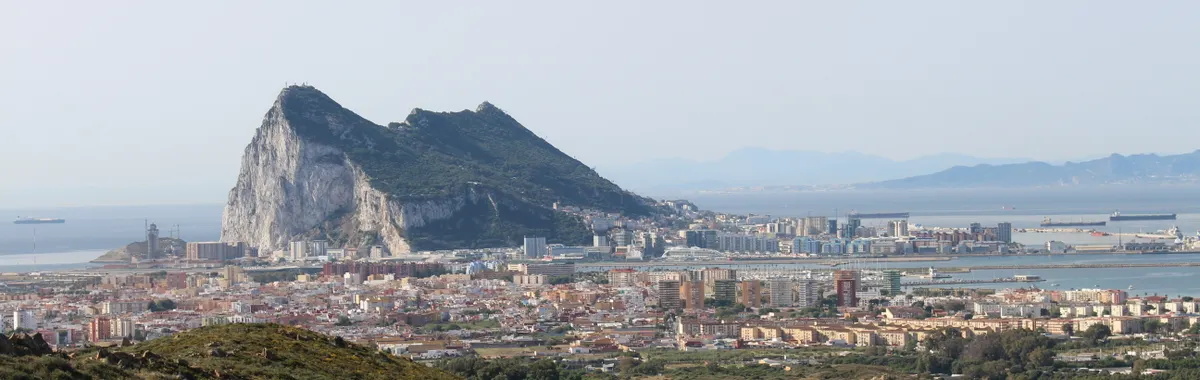 A clear view of the iconic Rock of Gibraltar from a distance, capturing the cityscape and coastal beauty.