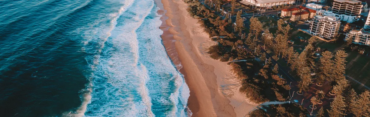 Stunning aerial shot of Wollongong Beach with city buildings in NSW, Australia.