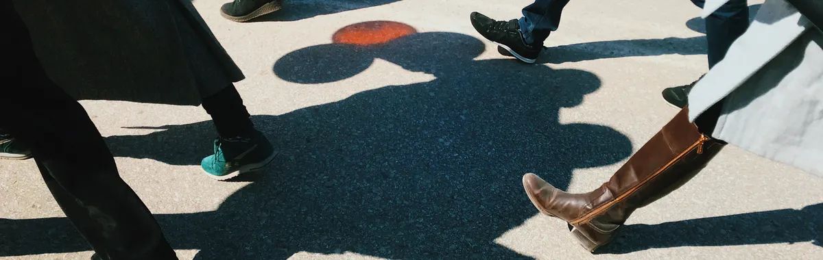 A vibrant street view showcasing people walking with distinct shadow play on Yakutsk pavement.