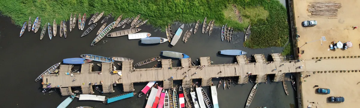 בנין: Aerial shot of the Ganvié pier with numerous boats moored in Benin.