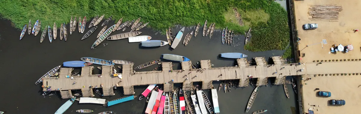 בנין: Aerial shot of the Ganvié pier with numerous boats moored in Benin.