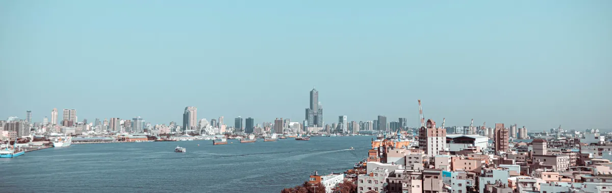 A stunning aerial view of Kaohsiung City skyline with ocean in the foreground.