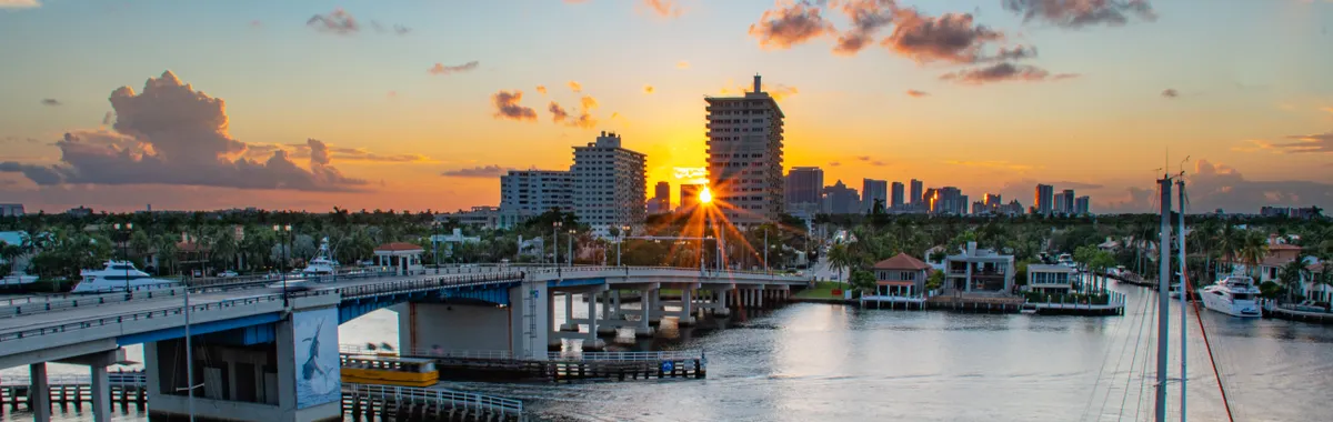Picturesque sunrise over Las Olas Bridge in Fort Lauderdale, capturing the marina and skyline.